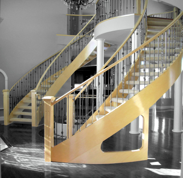 J- curved wooden stringer staircase with glass railing 